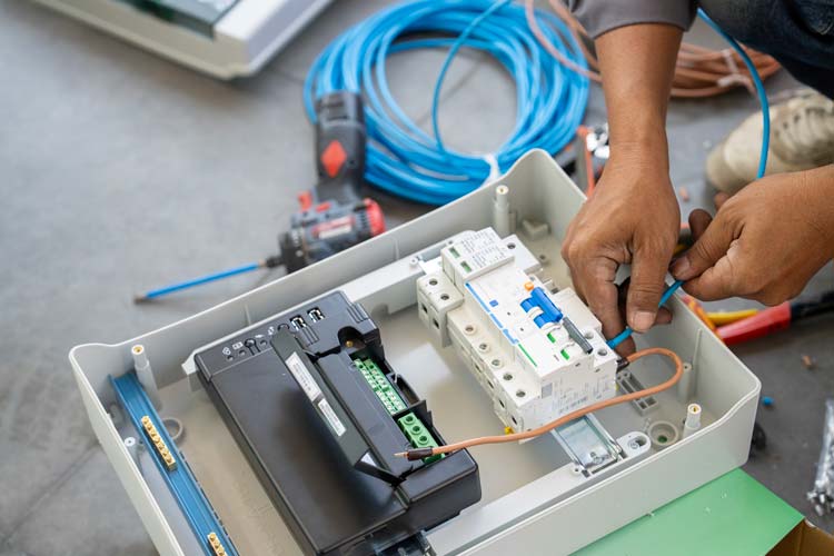 Elektriker som kopplar ström i ett proppskåp