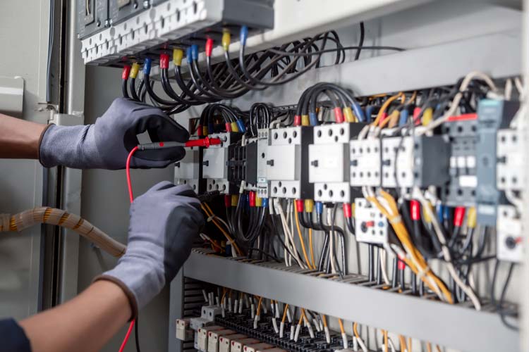 Elektriker som felsöker i ett elskåp